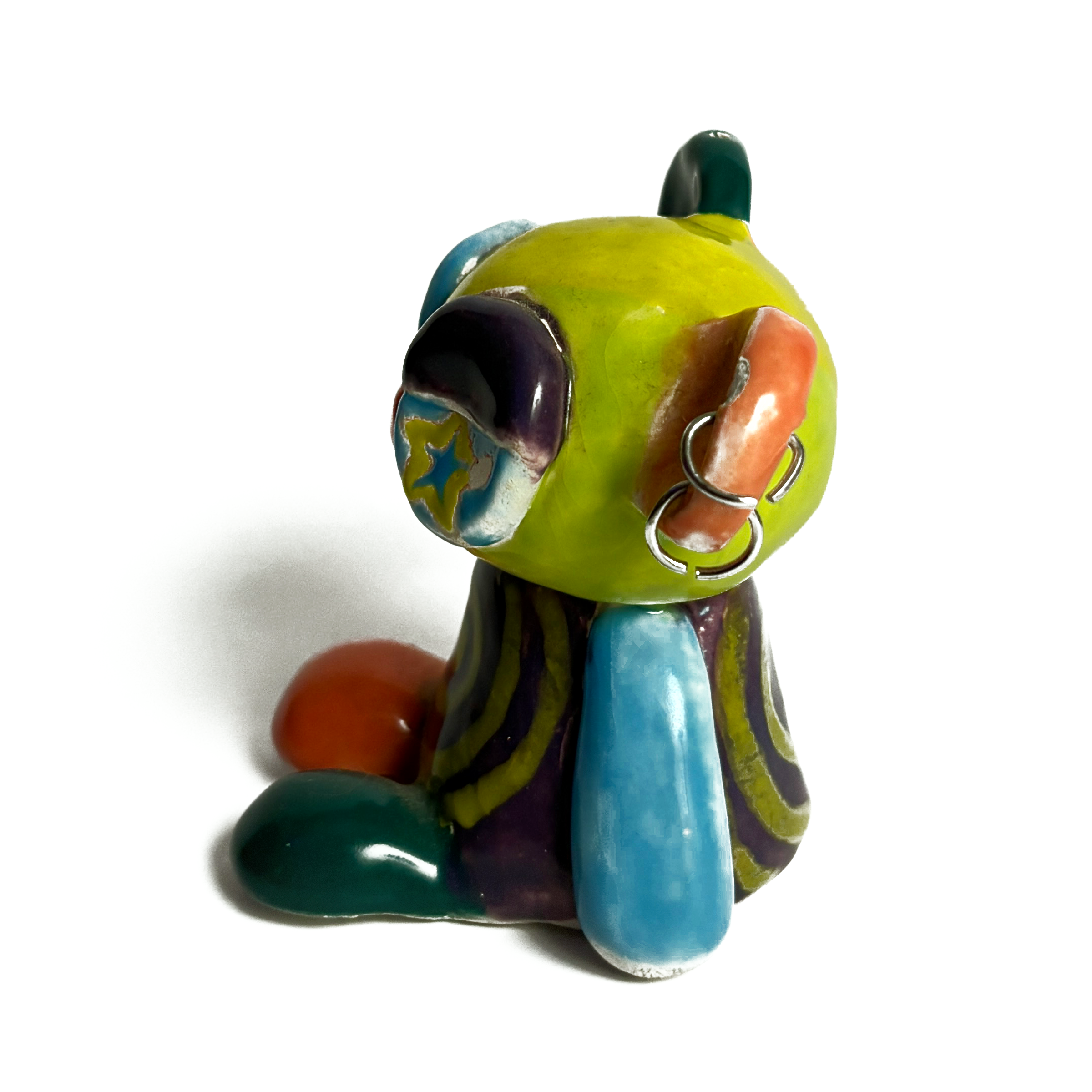 Left side of the ceramic bear, showing its blue arm and the rings in its ear.