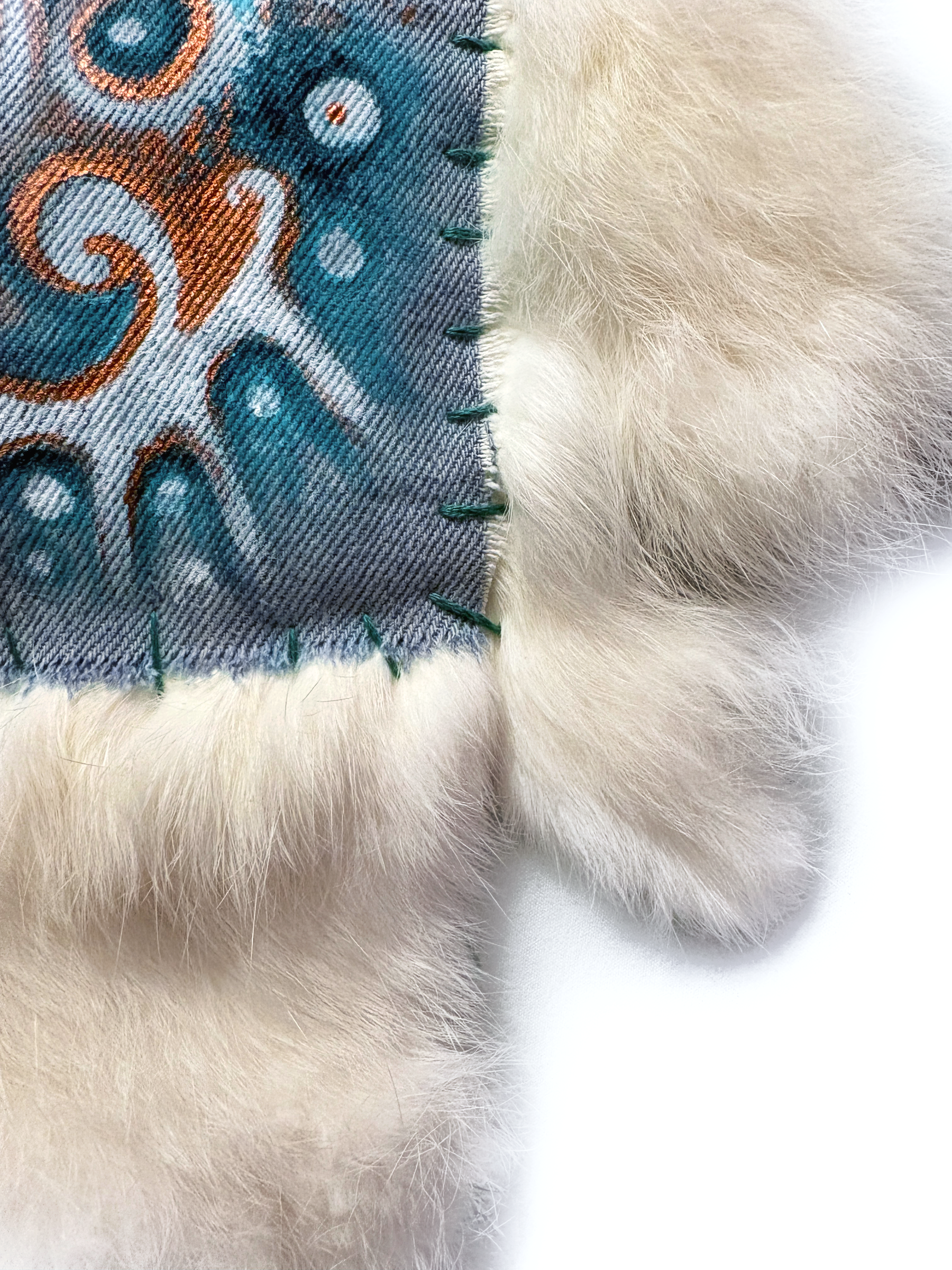 Detail of the stitched edge where the painted panel joins the fur.