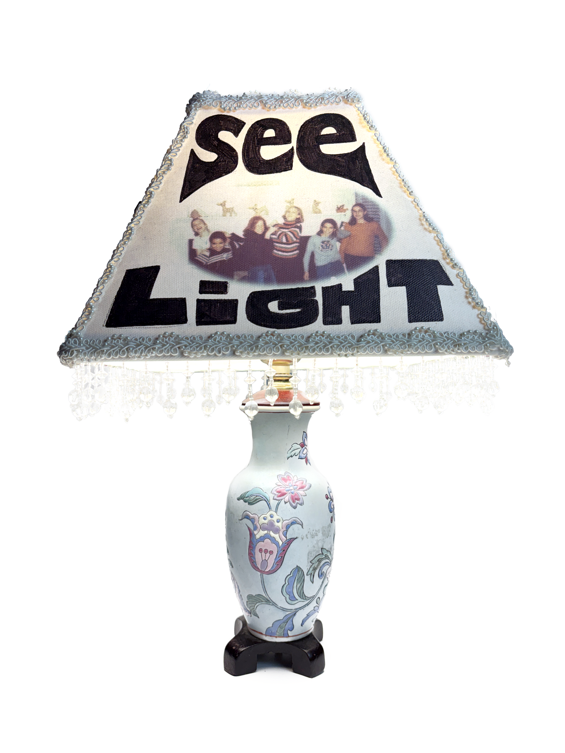 The same lamp from another side, its shade lettered SEE LIGHT around the same group photo.