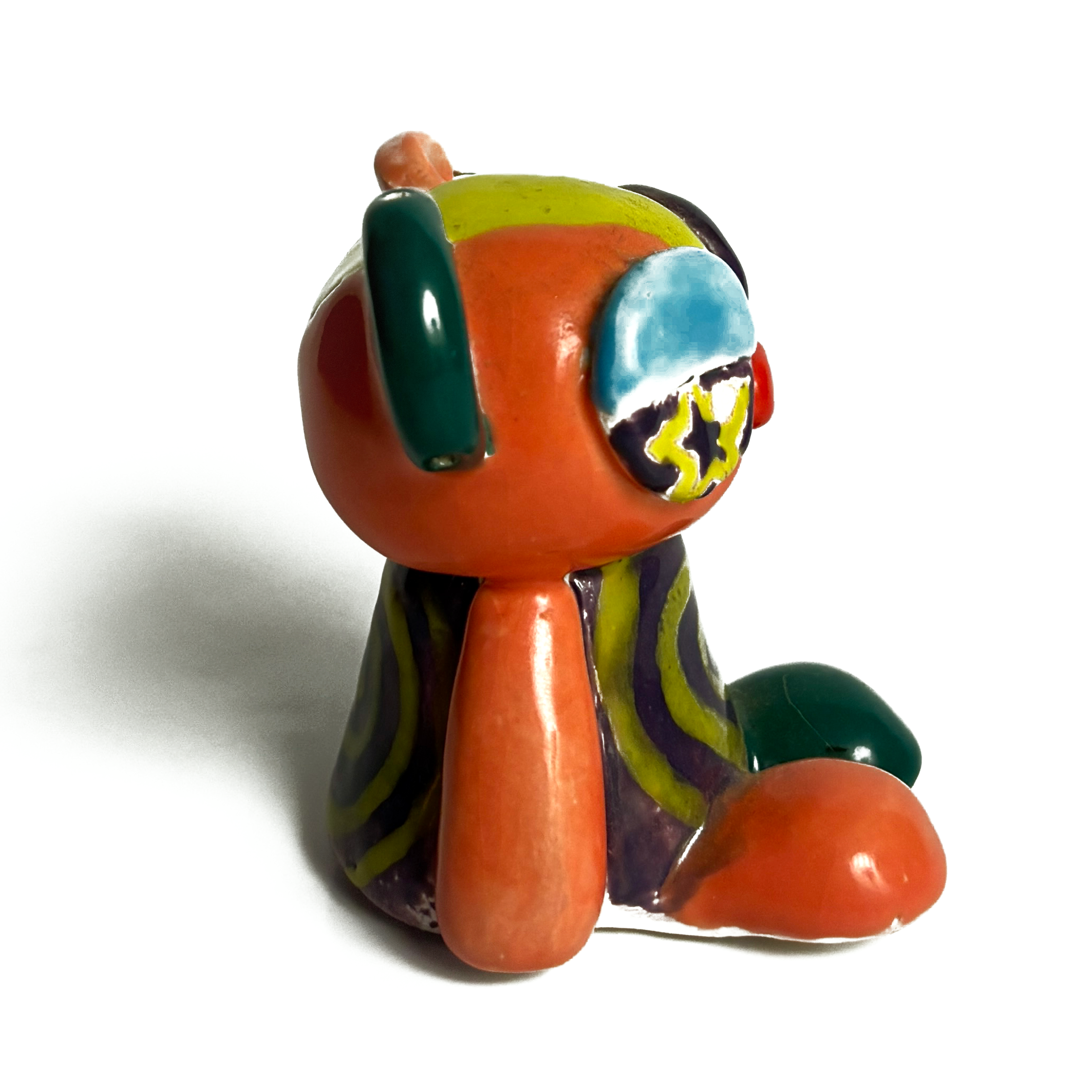 Right side of the ceramic bear, mostly orange, with a teal ear and a star-shaped eye.